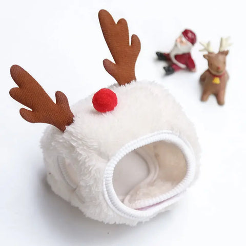 White pet bed with reindeer antlers and red nose on white background