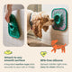 Dog licking treats from a green suction cup LickMat attached vertically to bathroom tiles.