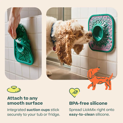 Dog licking treats from a green suction cup LickMat attached vertically to bathroom tiles.