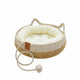 Woven pet bed with plush cushion on wooden floor with rope toy.