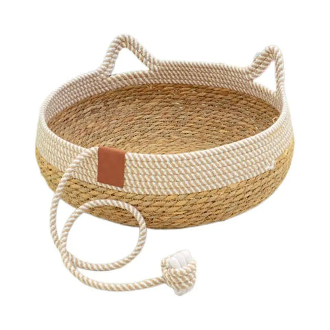 Woven pet bed with rope handles and decorative rope tie on white.